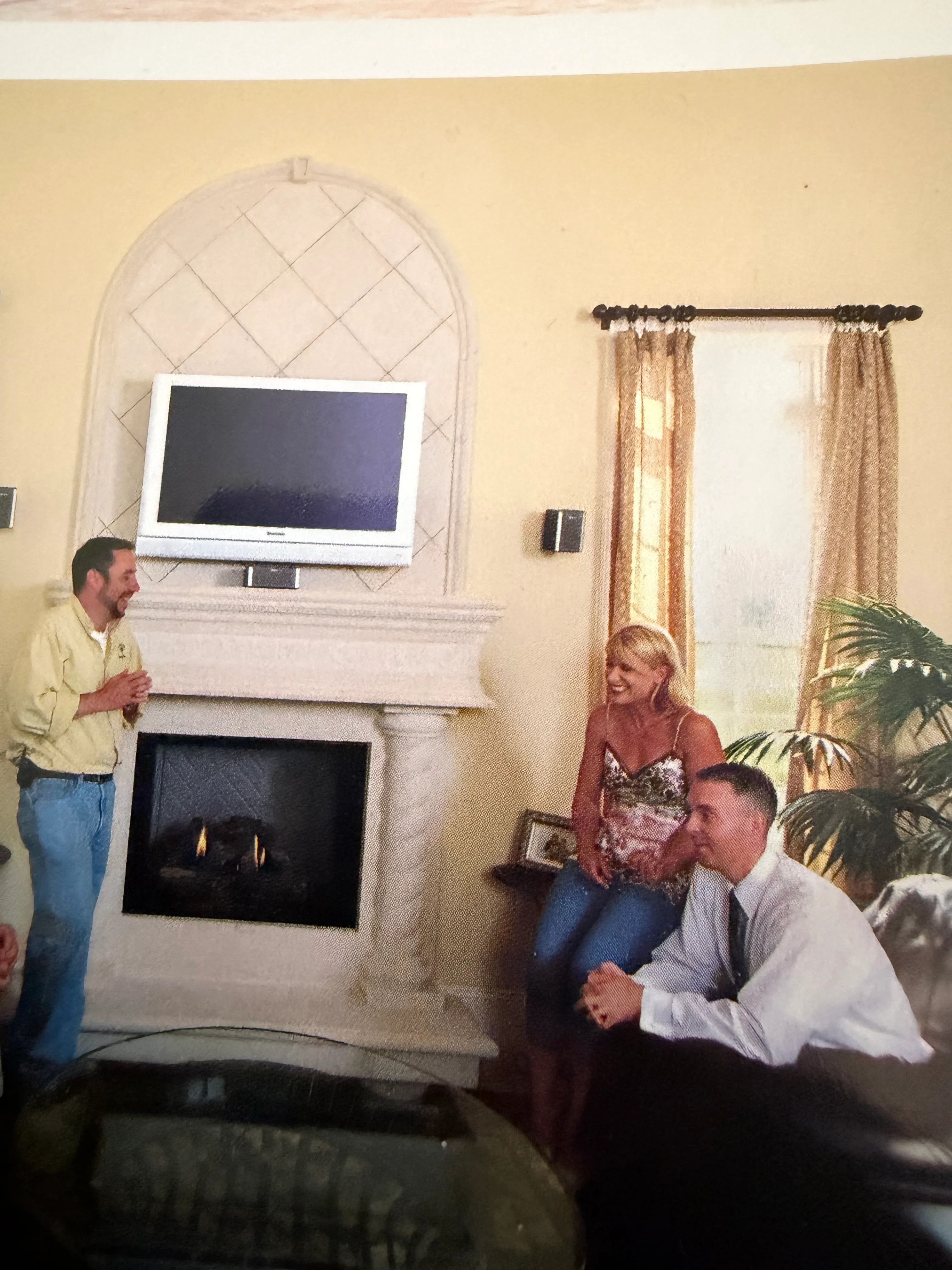 Arched fireplace with white TV mount, gas insert, and quilted accent wall detail